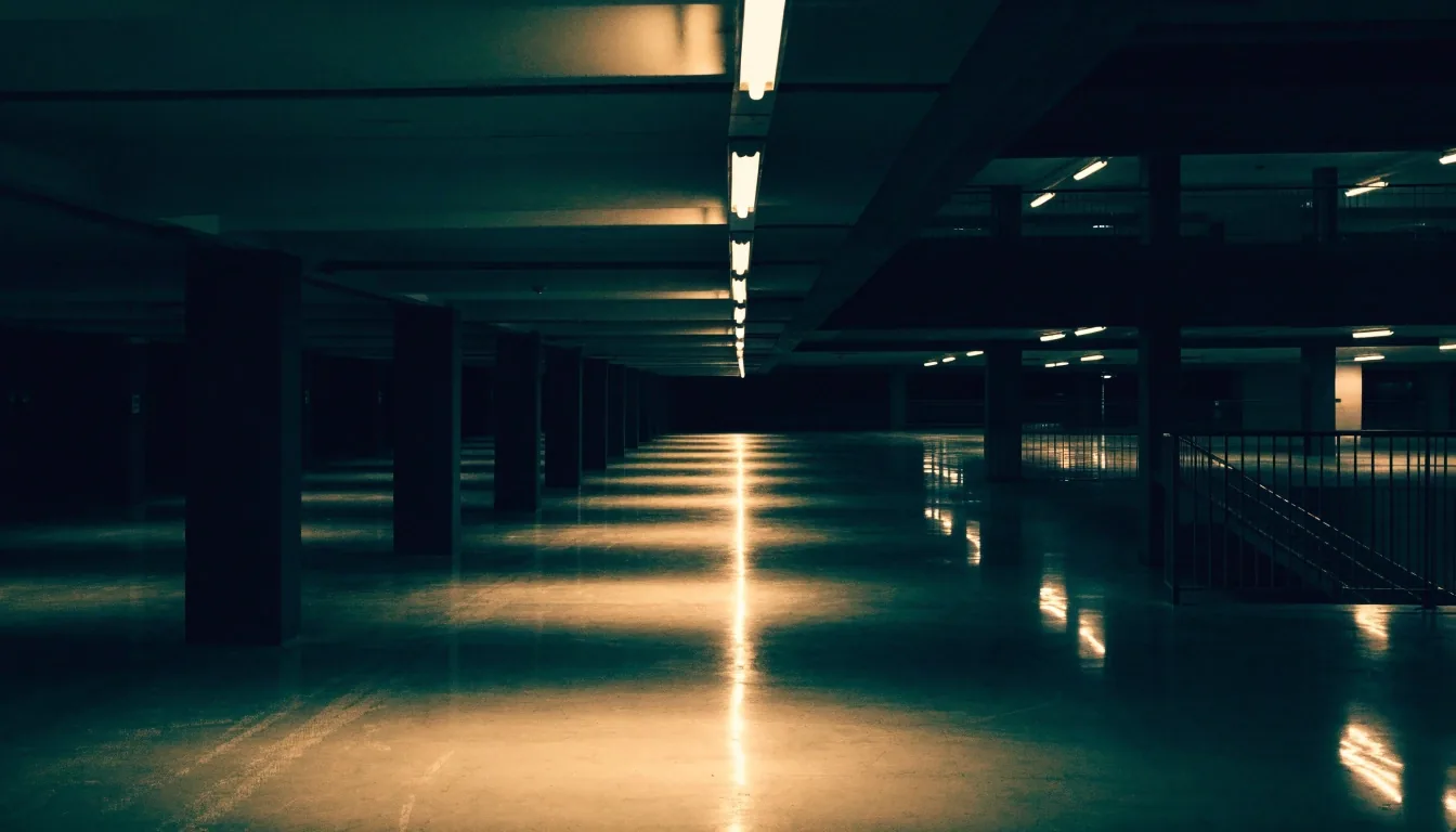 An empty Sydney car park deck at night with one lit row of bays